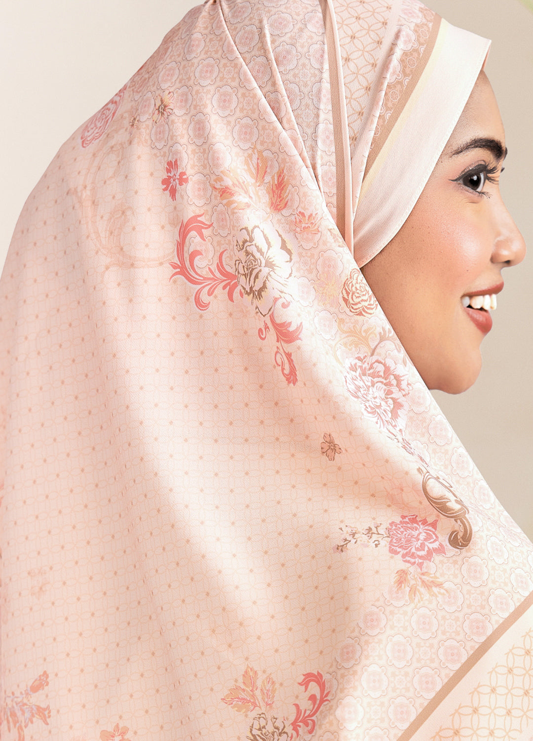 Woman wearing a floral hijab with a soft pink background