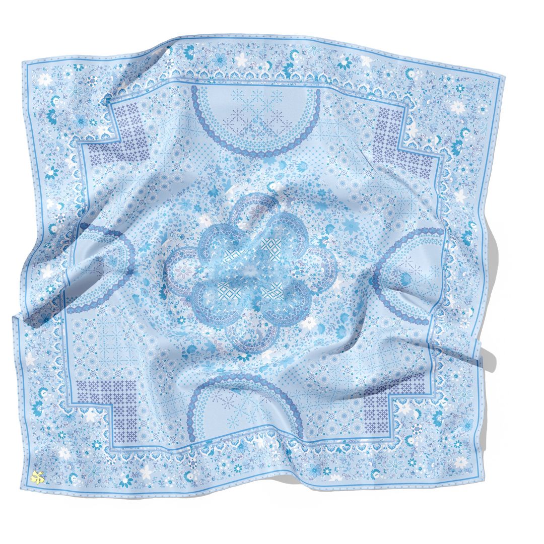 Blue patterned square scarf with a floral design on a white background