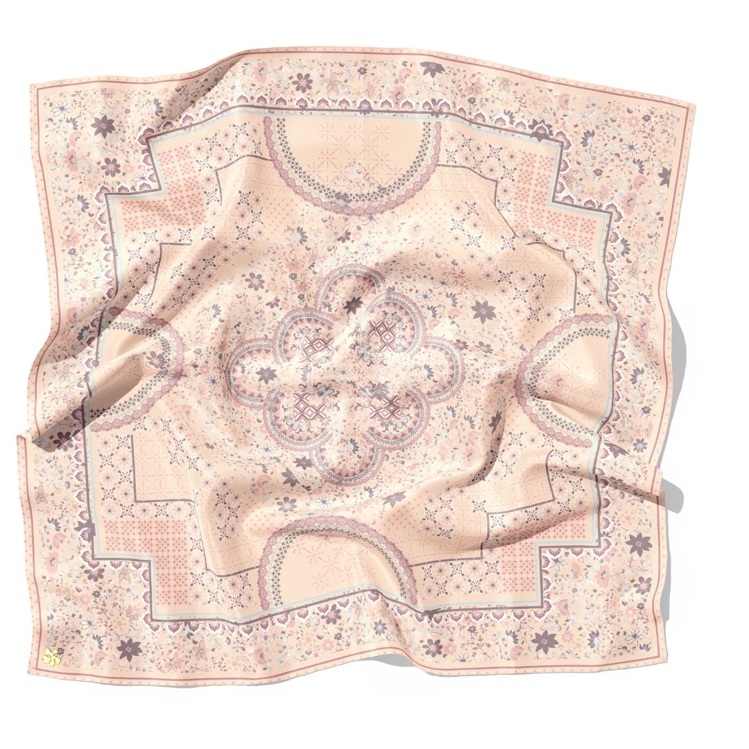Decorative pink scarf with intricate patterns on a white background