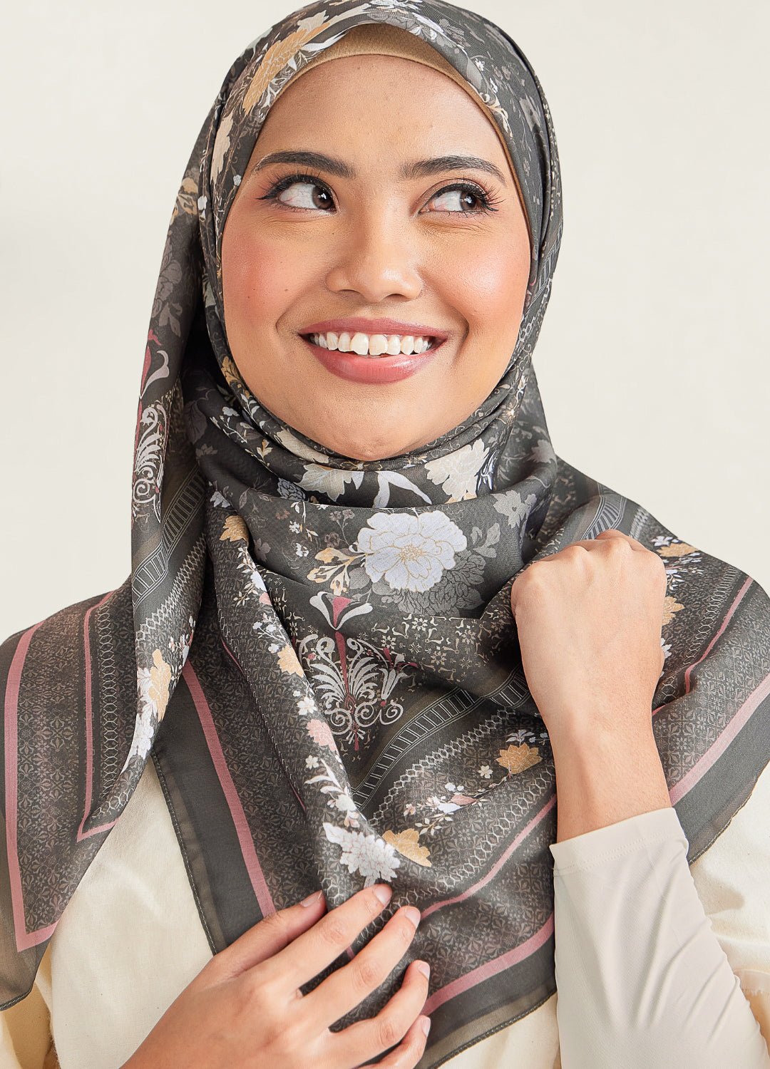 Woman wearing a floral hijab with a neutral background