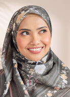 Woman wearing a floral hijab against a plain background
