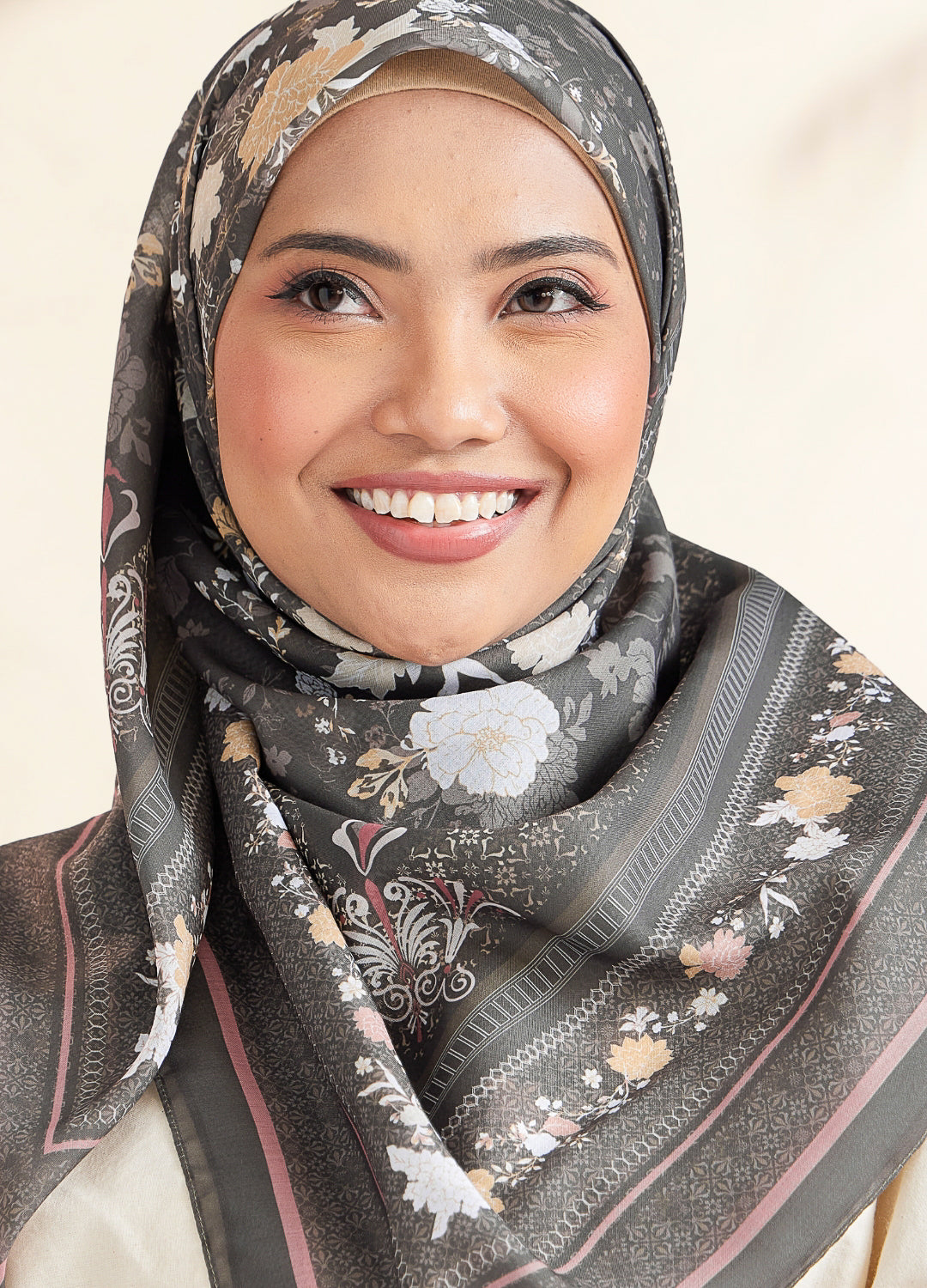 Woman wearing a floral hijab with a neutral background