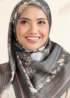 Woman wearing a floral hijab with a neutral background