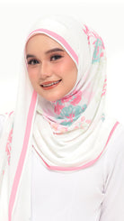A woman wearing a white hijab with pink stripes and a pink, teal, and green floral print, paired with a white top against a plain white background.