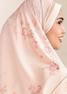 Woman wearing a floral hijab with a soft pink background