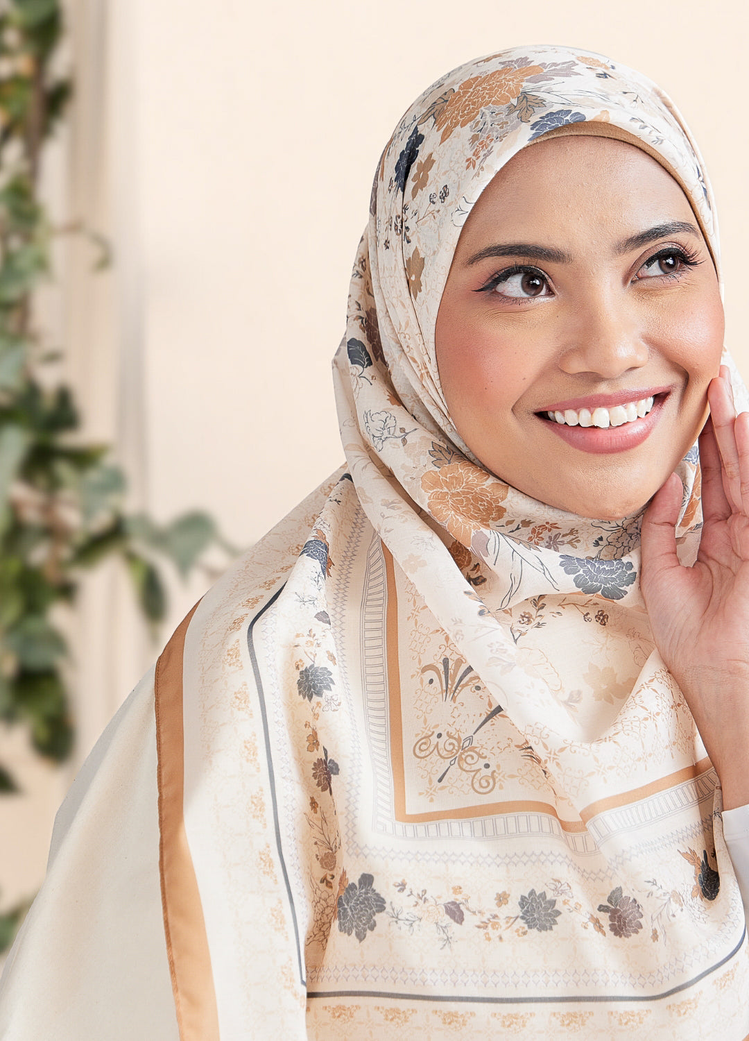 Woman wearing a floral hijab with a neutral background
