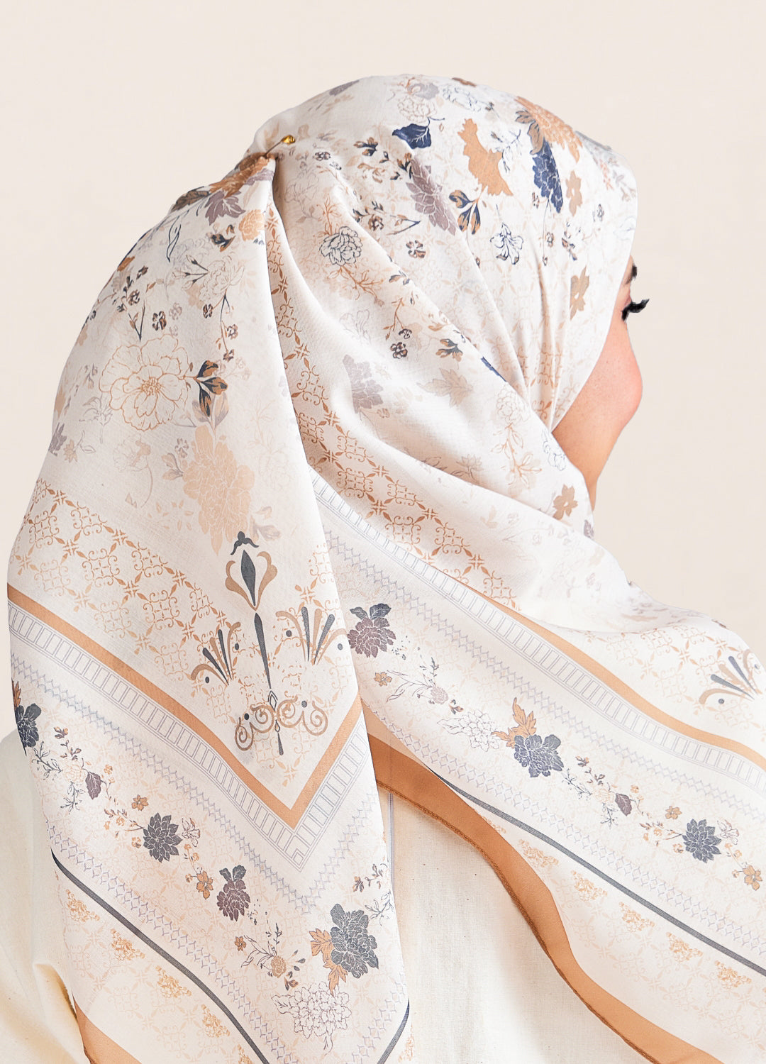 White hijab with floral and geometric patterns on a neutral background