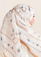 White hijab with floral and geometric patterns on a neutral background