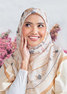 Woman wearing a floral hijab with a light background