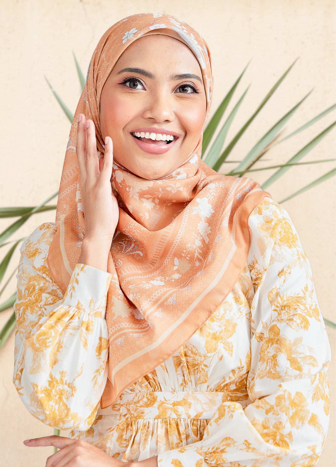 Women wearing floral cotton square hijab in sand gold color with blurred background