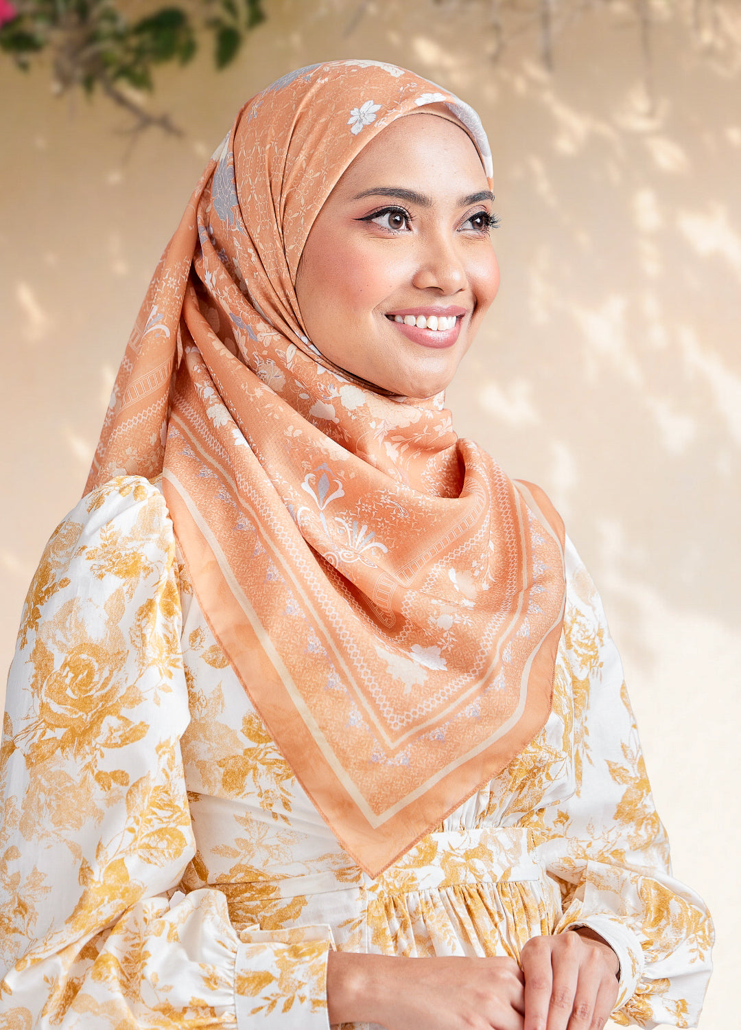 Women wearing sand gold color hijab with blurred outdoor background