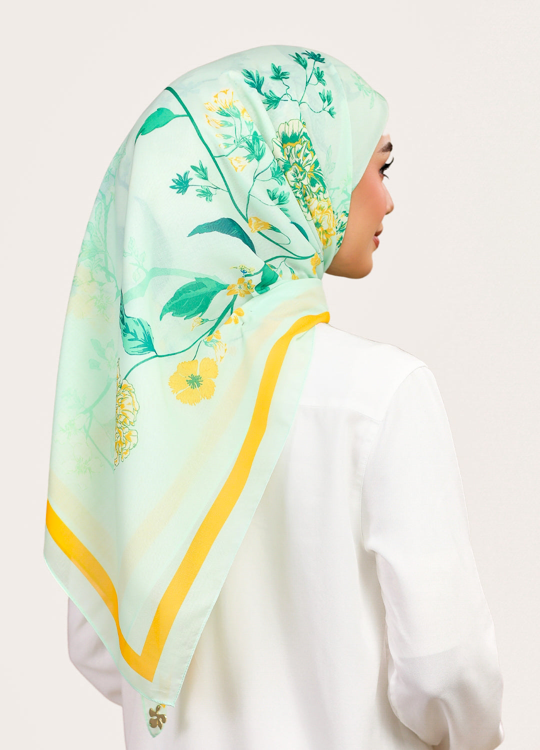 Model wearing printed intricate floral cotton tudung bawal - light green